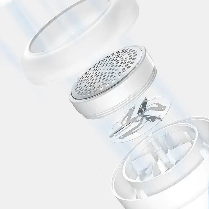 Hand houdt ergonomische witte FluffAway pluizenverwijderaar vast, perfect voor comfortabel huishoudelijk gebruik.