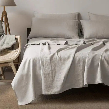 "Luxe linnen beddengoed, elegant en zacht, in diverse kleuren zoals abrikoos en donkergrijs. Perfect voor stijlvol comfort."