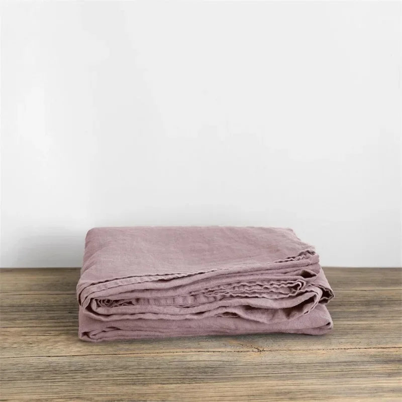 "Luxe linnen beddengoed, elegant en zacht, in diverse kleuren zoals abrikoos en donkergrijs. Perfect voor stijlvol comfort."