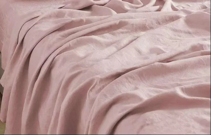 "Luxe linnen beddengoed, elegant en zacht, in diverse kleuren zoals abrikoos en donkergrijs. Perfect voor stijlvol comfort."