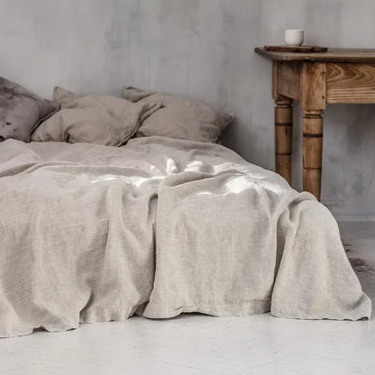 "Luxe linnen beddengoed, elegant en zacht, in diverse kleuren zoals abrikoos en donkergrijs. Perfect voor stijlvol comfort."