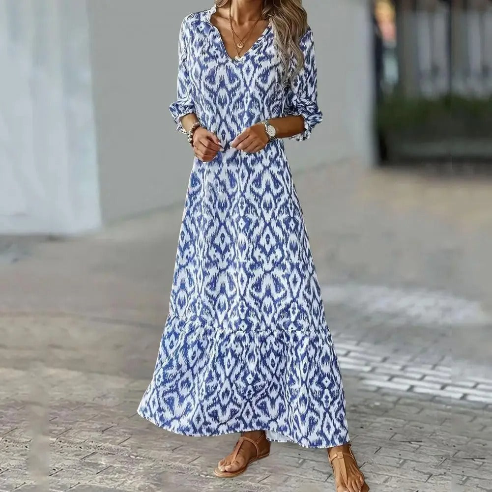 Elegante dames zomerjurk met v-hals en a-lijn pasvorm, ideaal voor strand of vakantie, verkrijgbaar in wit en blauw.