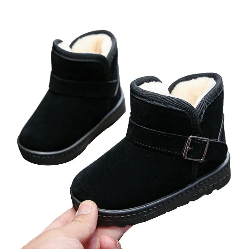 Blij kind draagt Boston Mini kinderlaarzen, genietend van warmte en comfort tijdens het spelen.