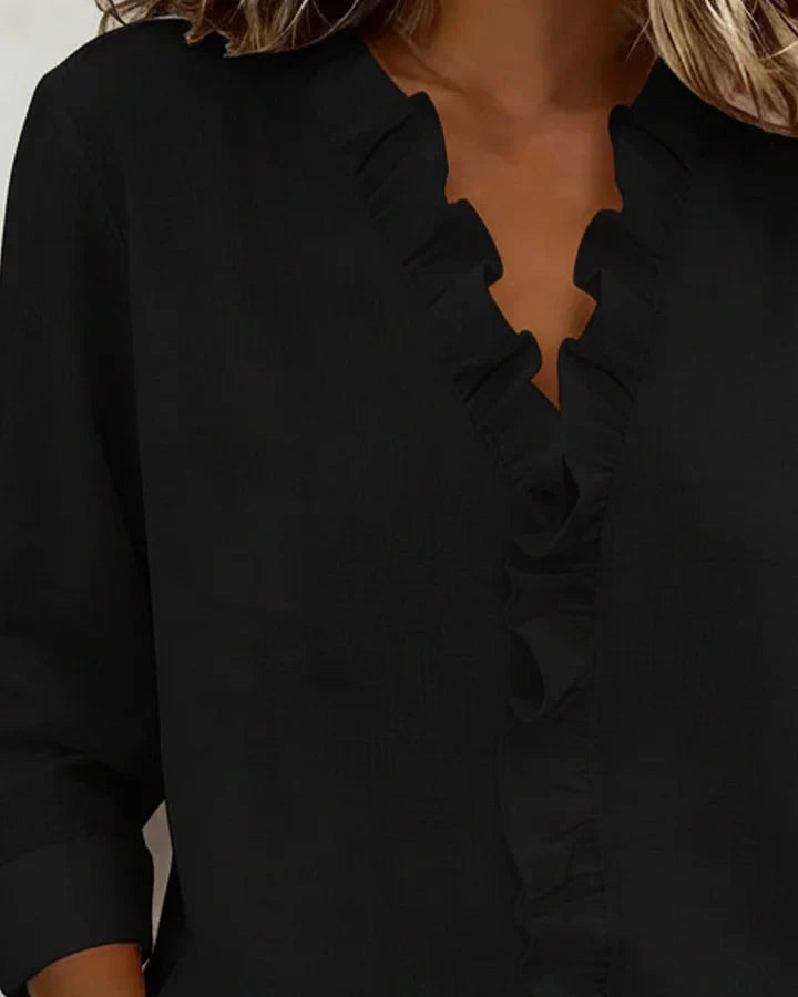 Zwarte elegante dames top met ruche details en V-hals. Lange mouwen, casual chic.