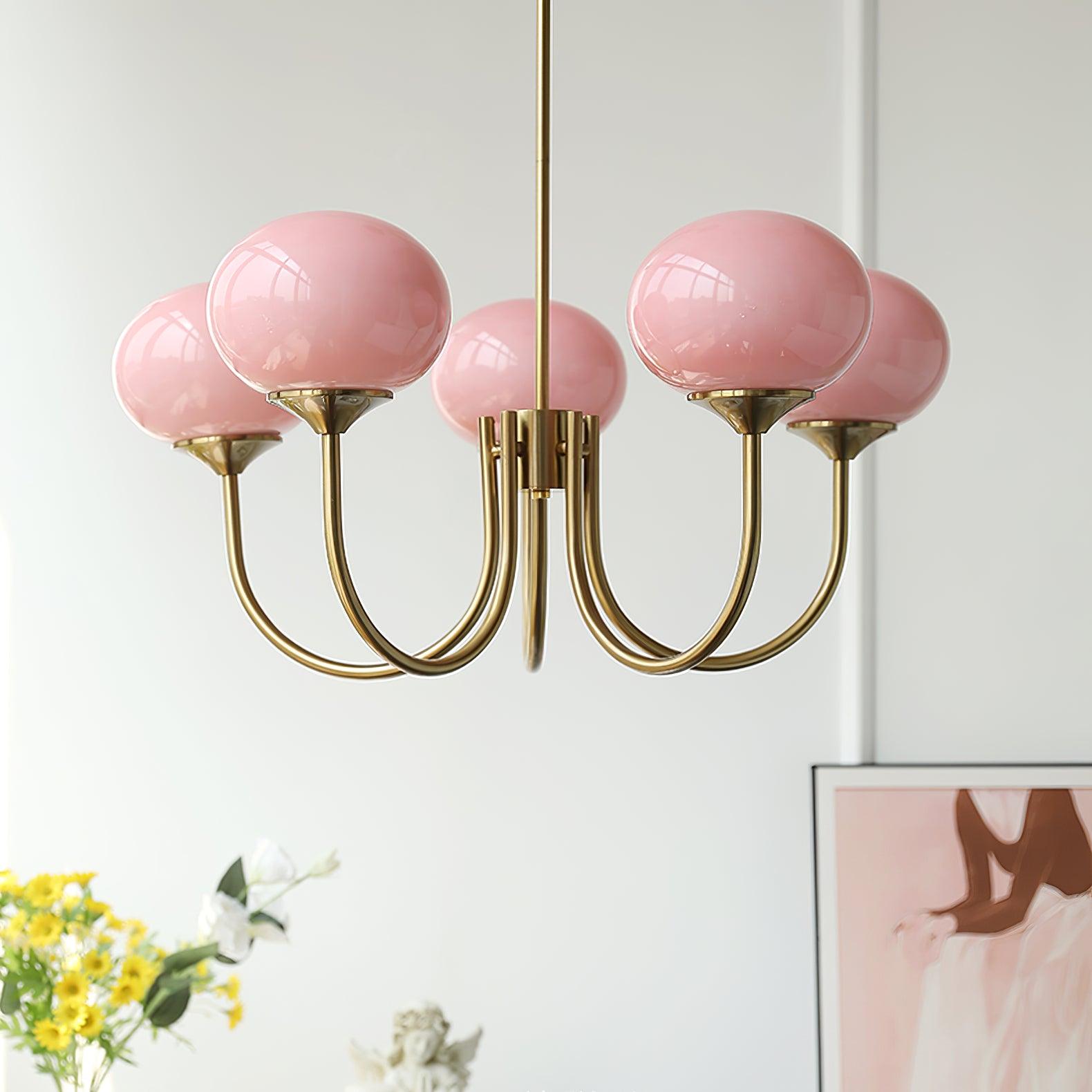 "Moderne kroonluchter met gouden afwerking en roze glazen kappen, geschikt voor LED verlichting in eigentijds interieur."