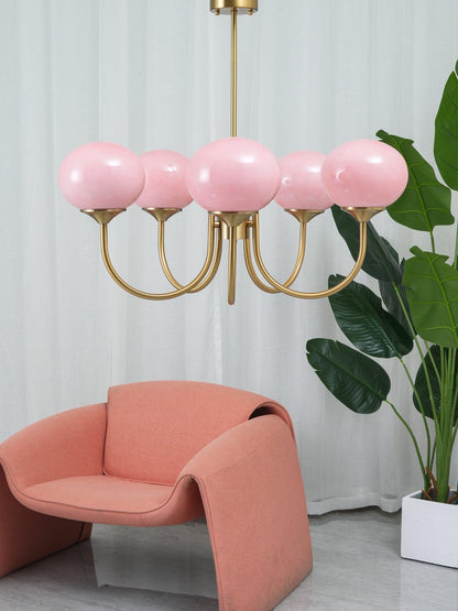"Moderne kroonluchter met gouden afwerking en roze glazen kappen, geschikt voor LED verlichting in eigentijds interieur."