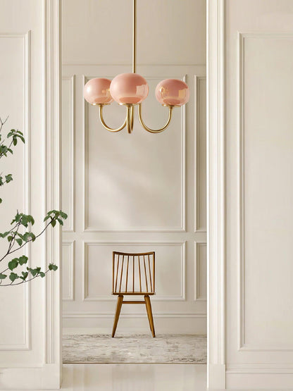 "Moderne kroonluchter met gouden afwerking en roze glazen kappen, geschikt voor LED verlichting in eigentijds interieur."