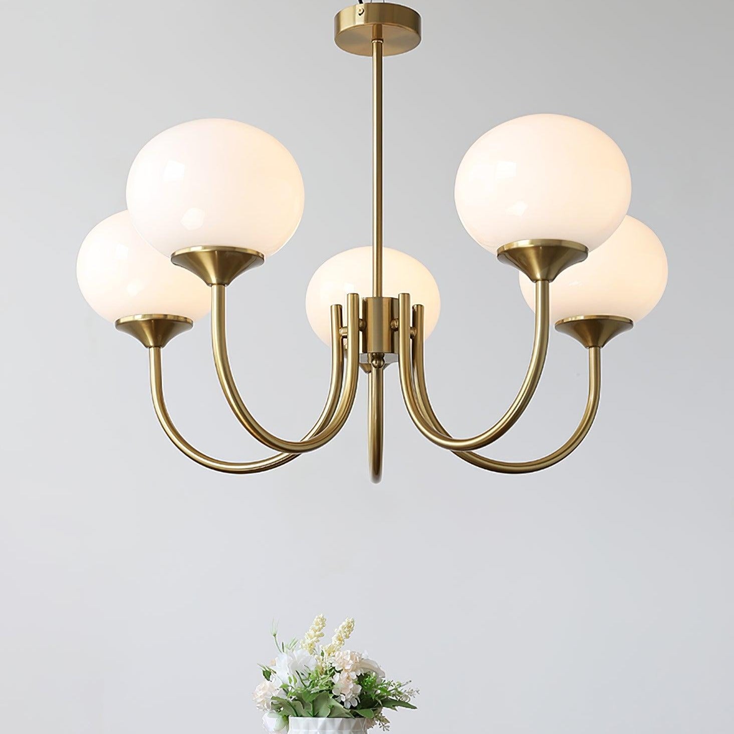 "Moderne kroonluchter met gouden afwerking en roze glazen kappen, geschikt voor LED verlichting in eigentijds interieur."