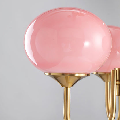 "Moderne kroonluchter met gouden afwerking en roze glazen kappen, geschikt voor LED verlichting in eigentijds interieur."