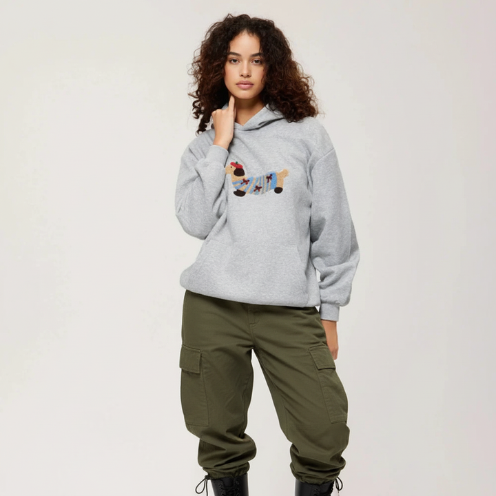Model draagt een gezellige dames hoodie met uniek teckel design. Comfortabele casual kleding.