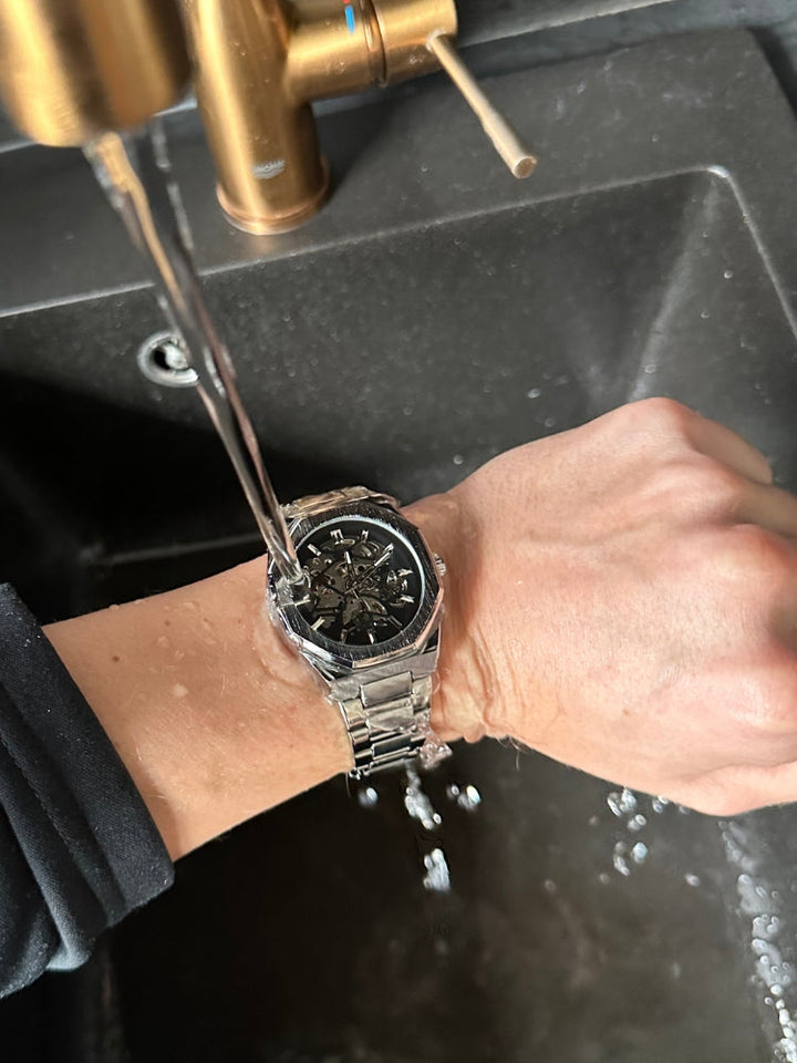 Luxe zilverkleurig automatisch herenhorloge met zwarte wijzerplaat, waterdicht en tijdloos.