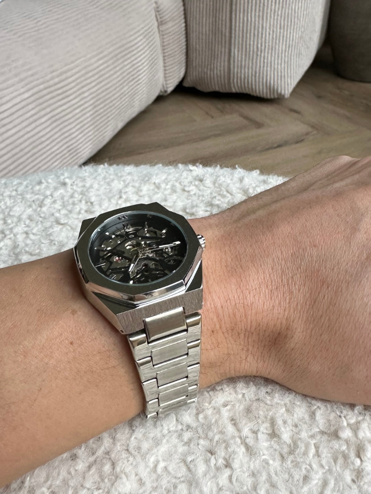 Detailopname wijzerplaat van luxe automatisch herenhorloge; precisie en stijlvol design.