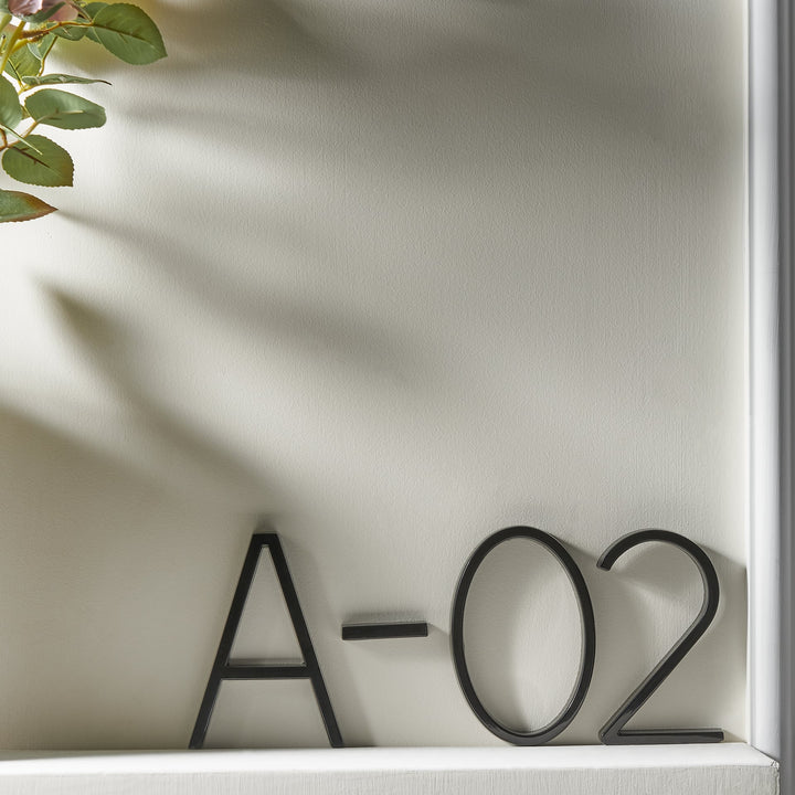 Elegant zwart huisnummer met zwevend effect, verrijkt de buitendecoratie van uw woning.