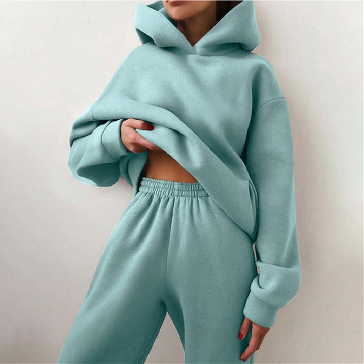 Model toont comfortabel oversized dames joggingpak, compleet met ruime hoodie en trendy hoge taille broek.