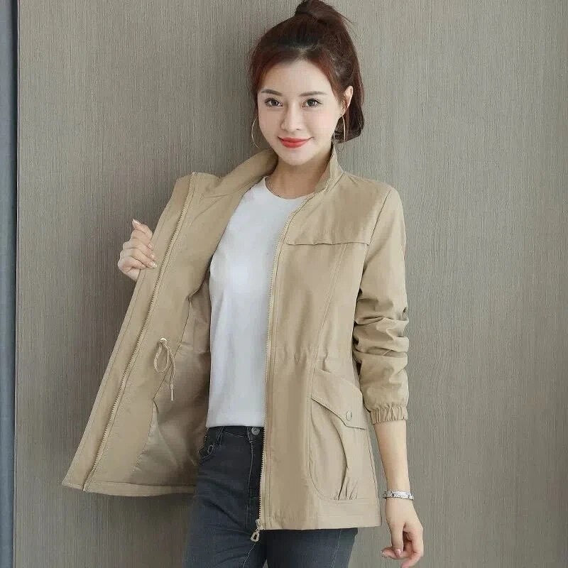 Casual beige dames trenchcoat gedragen, verstelbare taille accentueert silhouet. Comfortabele bovenkleding.