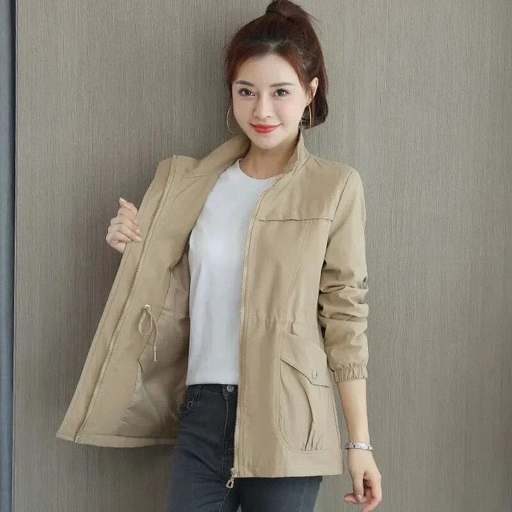 Casual beige dames trenchcoat gedragen, verstelbare taille accentueert silhouet. Comfortabele bovenkleding.