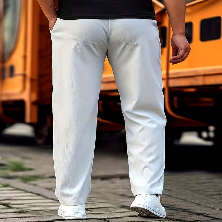 Model draagt een stijlvolle en comfortabele grijze casual herenbroek van elastische katoenmix.
