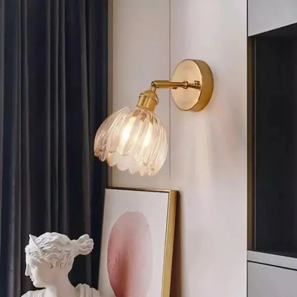 Retro wandlamp met heldere glazen tulp kap en schitterende gouden elementen.