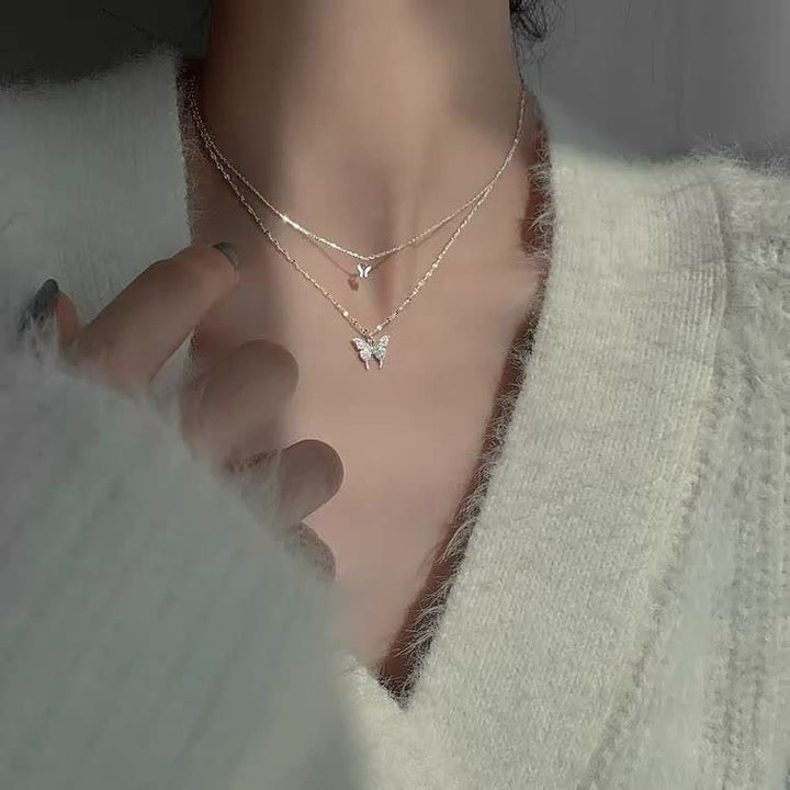 Close-up van een fijne zilveren vlinderketting voor dames, toont het ambacht en detail.