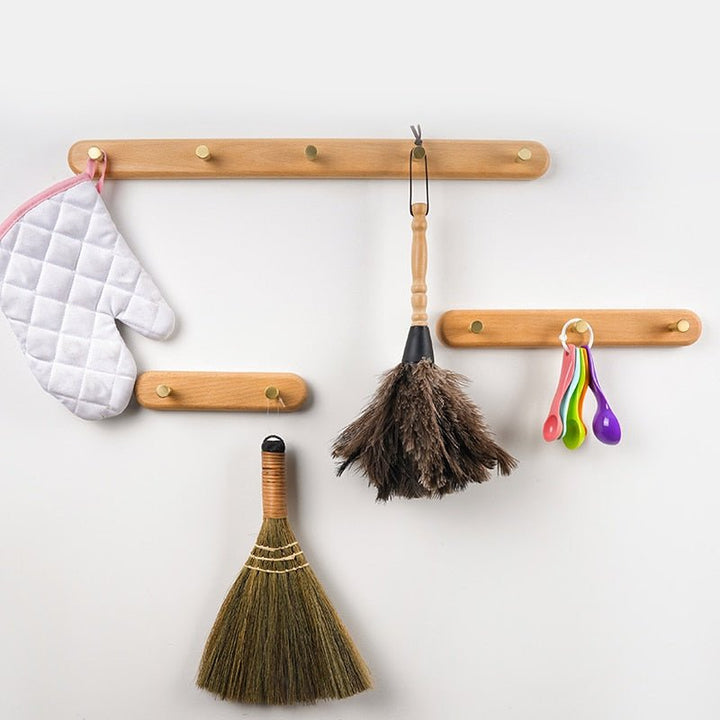 Unisex design LignaHook wandkapstok, gemaakt van hout met glanzende messing haken, modern en strak.