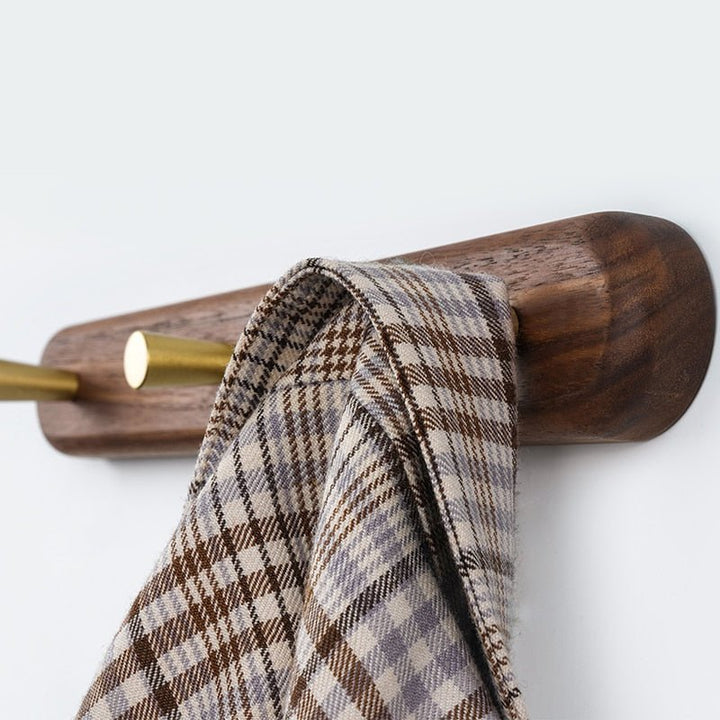 Minimalistische houten wandkapstok LignaHook met elegante messing haken voor modern interieur.