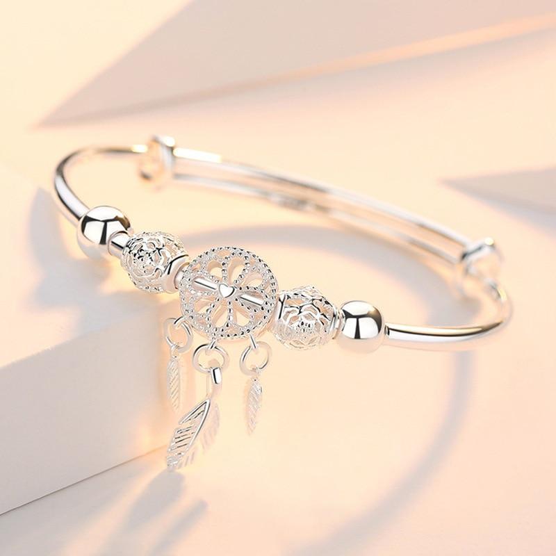 Verstelbare dames droomvanger armband van 925 zilver met gedetailleerd web en veren. Elegant zilveren sieraad.