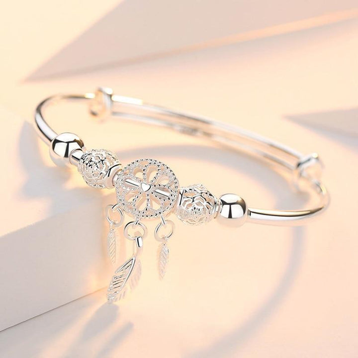 Verstelbare dames droomvanger armband van 925 zilver met gedetailleerd web en veren. Elegant zilveren sieraad.