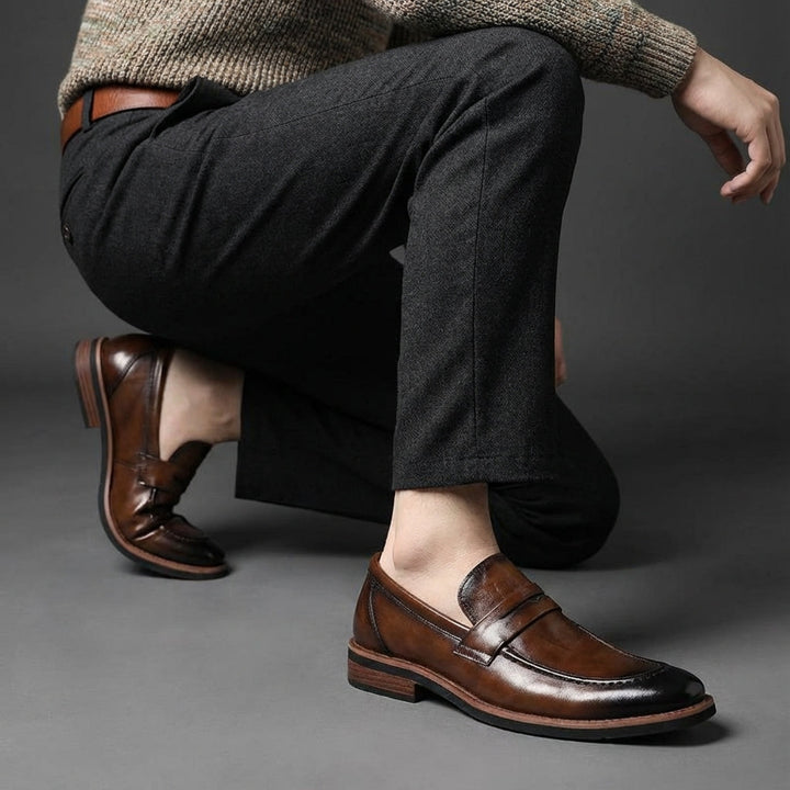Close-up van zwarte lederen heren instappers met subtiele stiksels, ideaal voor elke garderobe.