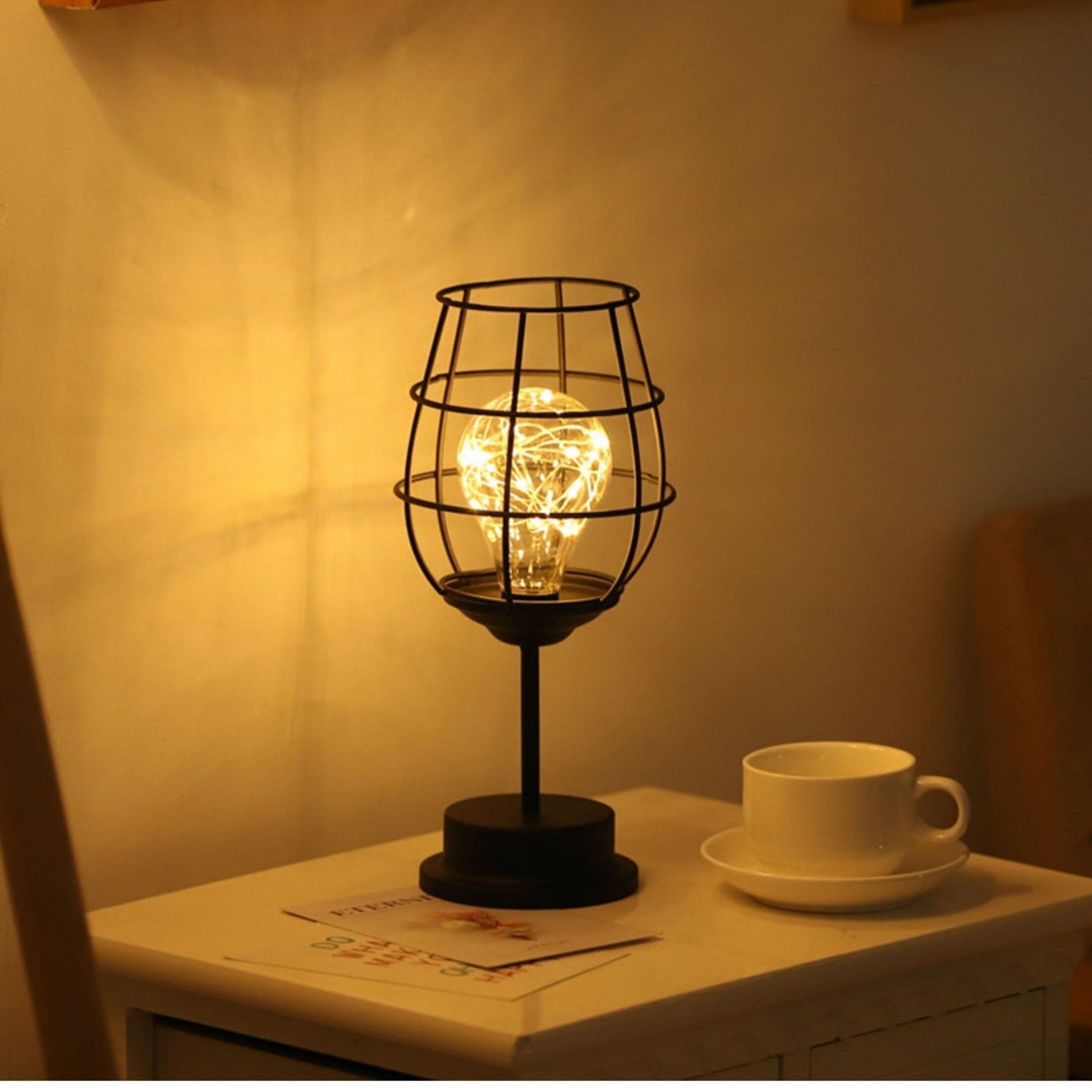 "Rustieke tafellamp met industrieel ontwerp, straalt warm licht uit, ideaal voor sfeerverlichting in moderne interieurs."