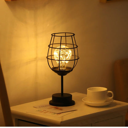 "Rustieke tafellamp met industrieel ontwerp, straalt warm licht uit, ideaal voor sfeerverlichting in moderne interieurs."