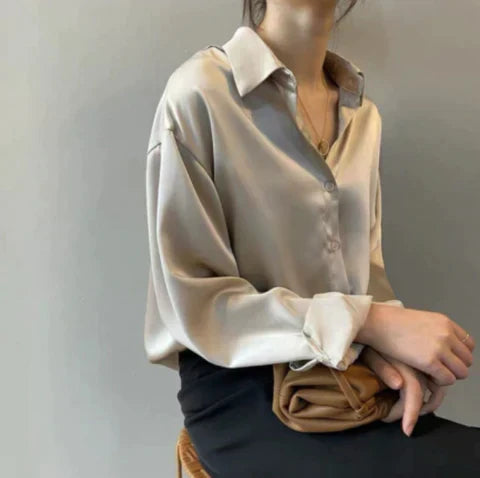 Elegante damesblouse met klassieke kraag en lange mouwen, losvallend en glanzend voor een zakelijke of casual chic look.