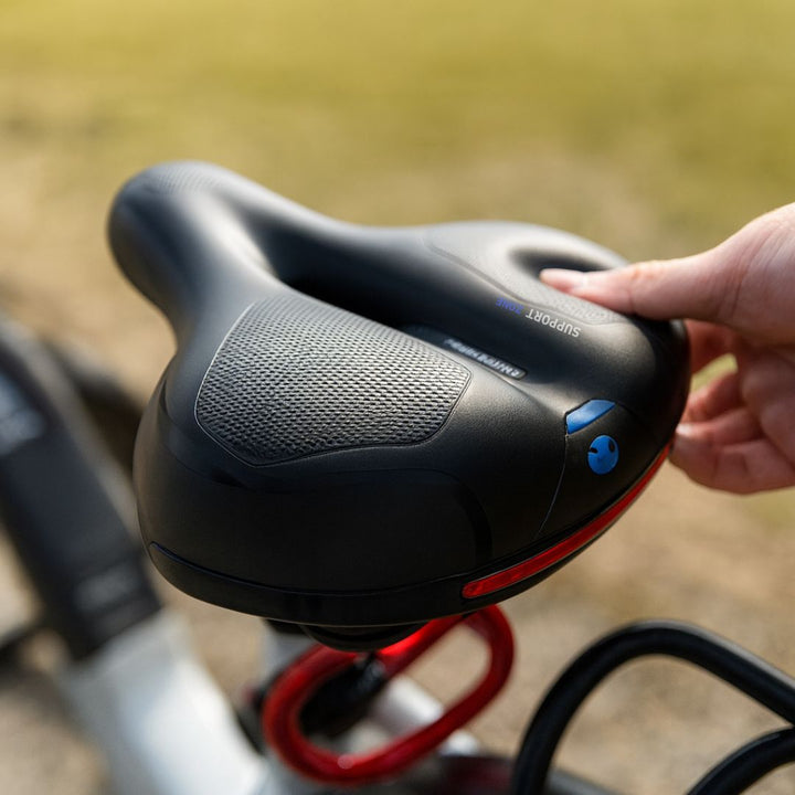 Rood comfort fietszadel voor heren & dames, met schokabsorberende vering en een reflecterende strip.