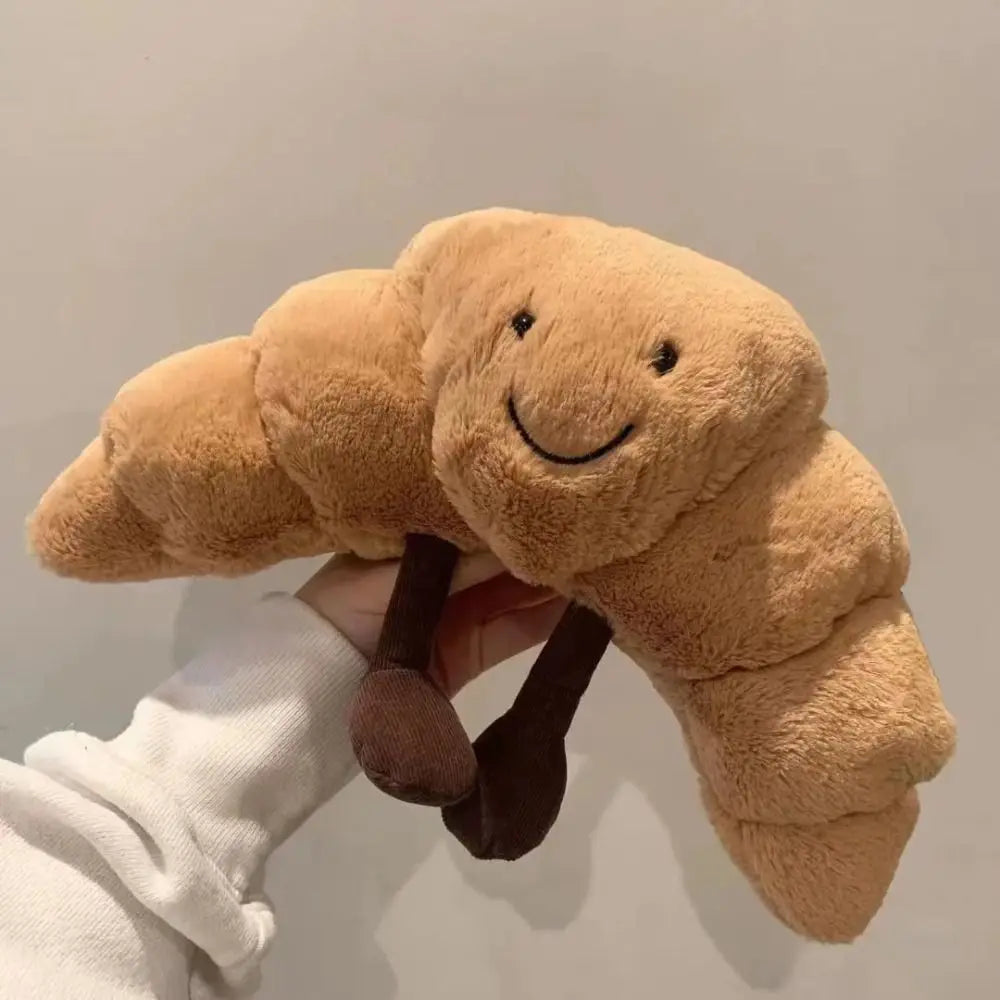 Lachende croissant knuffel, zacht pluche kussen, ideaal voor kinderkamer decoratie of als vrolijk cadeau.