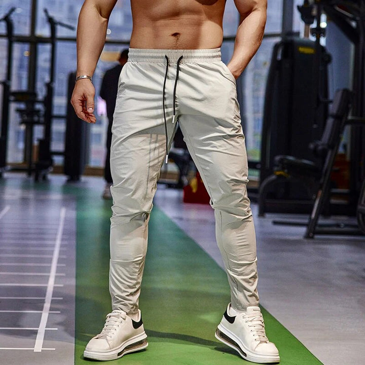 Zwarte heren joggers van sneldrogend spandex/polyester, perfect voor fitness, hardlopen en actieve sportkleding.