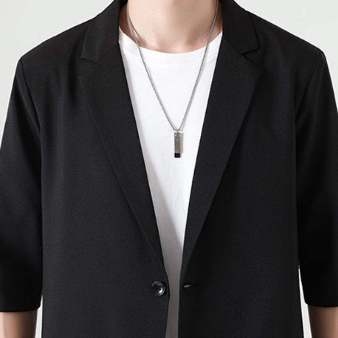 Man draagt complete zwarte tweedelige heren smart casual set; moderne en elegante kleding.