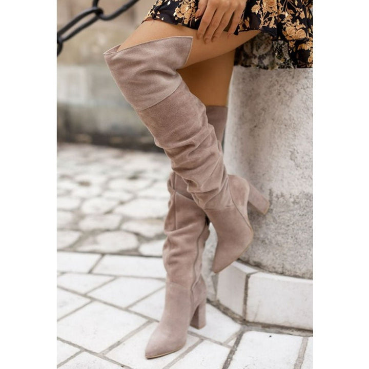 Bruine dames kniehoge laarzen met elegante hak, ideaal voor een chique herfst- of winterlook.