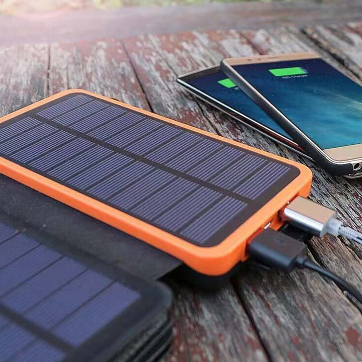 Robuuste solar powerbank met 4 panelen in een natuurlijke omgeving, klaar voor actie.