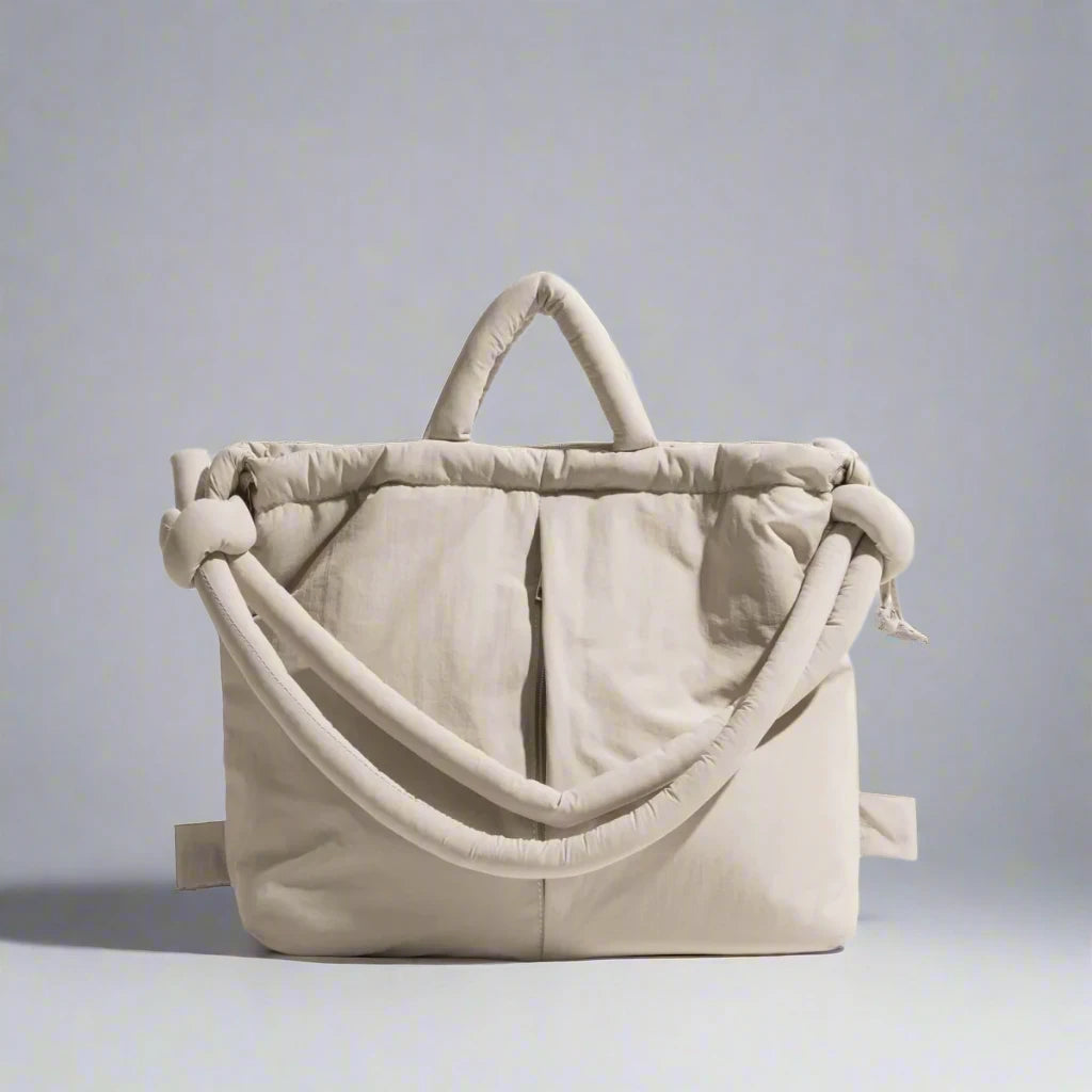 "Stijlvolle puffer handtas in beige met ruim design en comfortabele handgrepen voor vrouwen, perfect voor dagelijks gebruik."