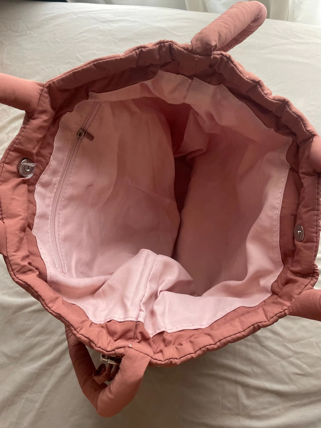 "Stijlvolle puffer handtas in beige met ruim design en comfortabele handgrepen voor vrouwen, perfect voor dagelijks gebruik."