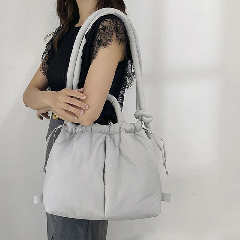 "Stijlvolle puffer handtas in beige met ruim design en comfortabele handgrepen voor vrouwen, perfect voor dagelijks gebruik."