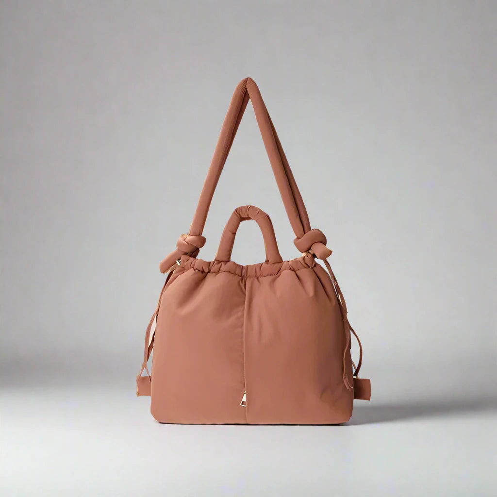 "Stijlvolle puffer handtas in beige met ruim design en comfortabele handgrepen voor vrouwen, perfect voor dagelijks gebruik."