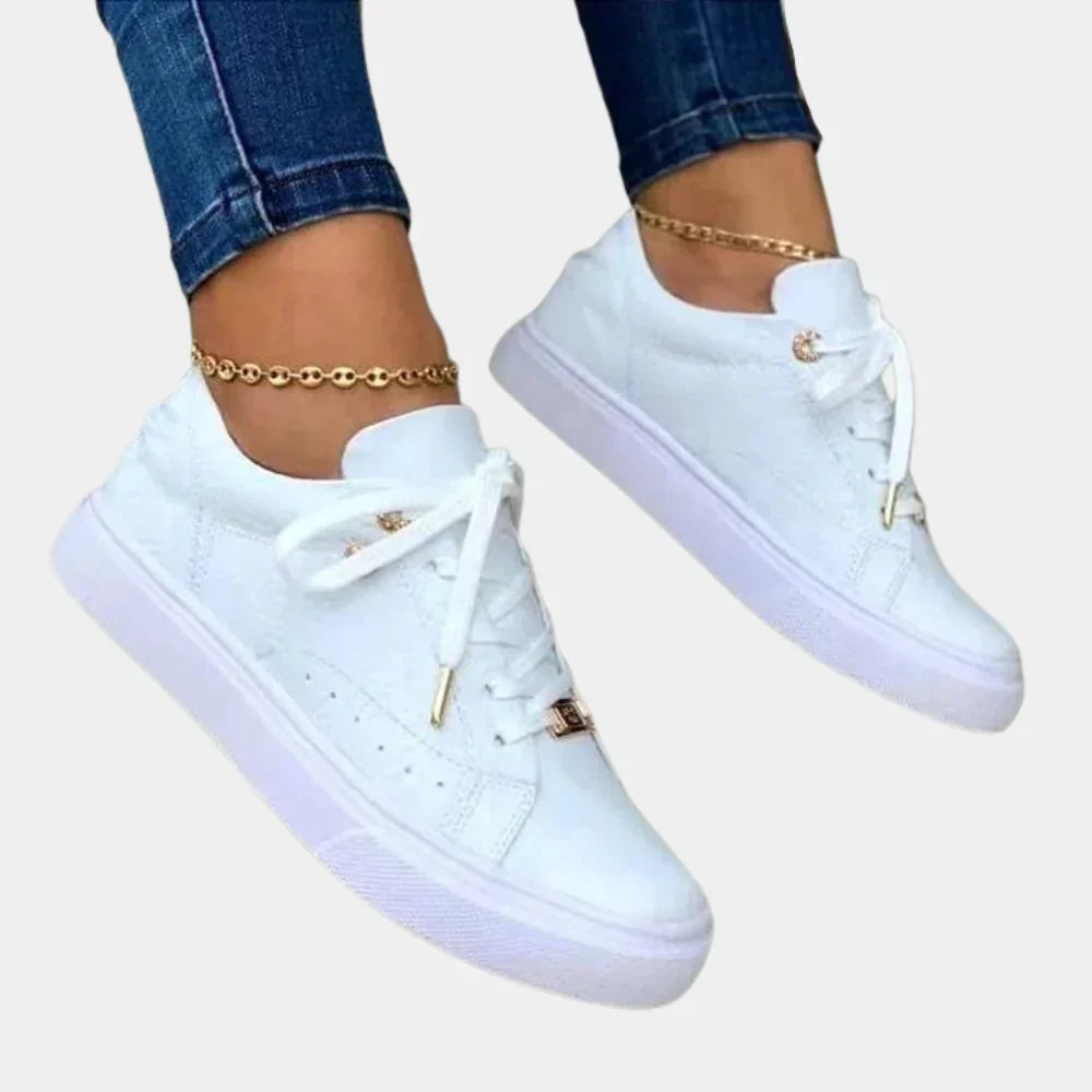 "Stijlvolle witte damessneakers van kunstleer met dempende zool, elegant design voor casual en semi-formele outfits."