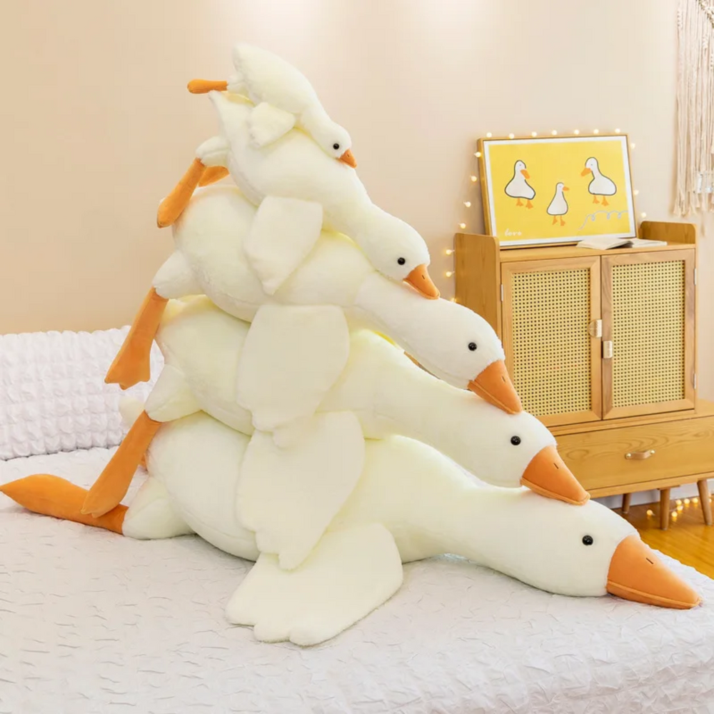 Blij kind knuffelt met grote zachte pluche gans. Ideaal speelgoed en decoratief kussen voor comfort.