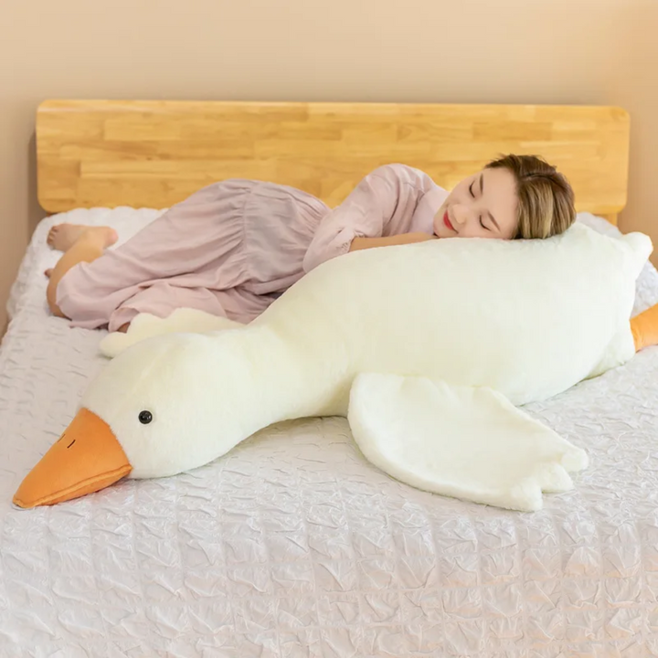 Grote knuffel gans als kussen in een kinderkamer. Zacht pluche speelgoed voor comfort en decoratie.