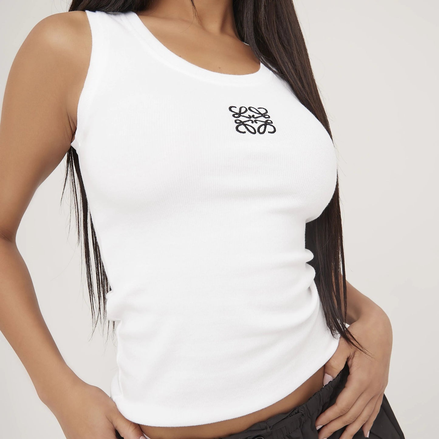 "Tanktop van zijdezacht katoen met minimalistisch design, ideaal voor zomer. Verkrijgbaar in grijs, wit en zwart."