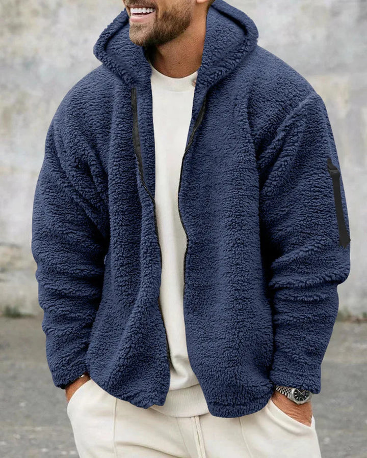 Close-up van de ritssluiting en stof van dit modieuze oversized heren bomberjack met capuchon.