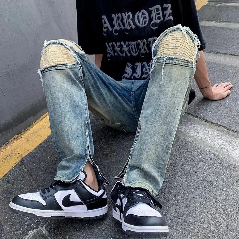 Man draagt een comfortabele blauwe herenjeans, ideaal voor een relaxte en stijlvolle urban look. Essentiële spijkerbroek.