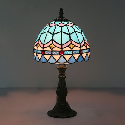 "Tiffany-stijl tafellamp, blauw en geel glas, klassieke loodlijnen, warme en uitnodigende sfeer, ambachtelijk design."