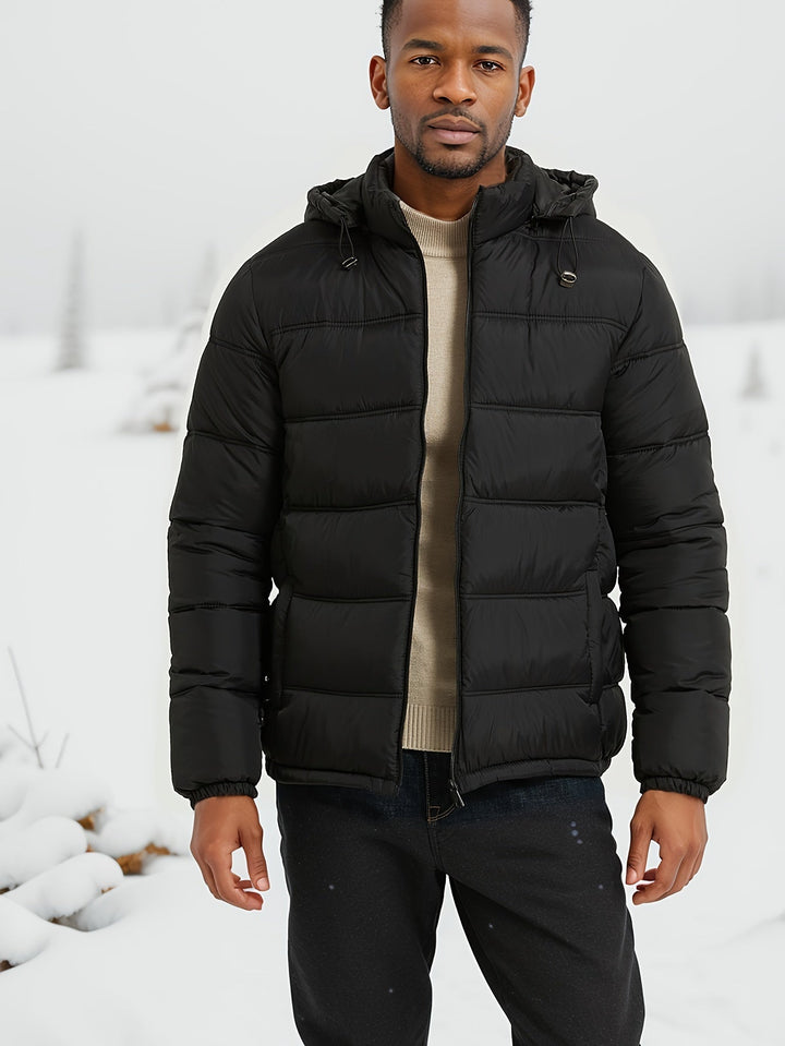 Heren Elegante Pufferjas: Zwarte winterjas met capuchon en ruime zakken, perfect voor een warme en casual herfstoutfit.