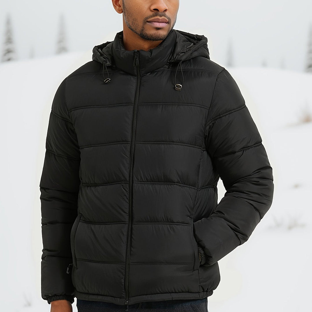 Man draagt stijlvolle zwarte heren pufferjas met capuchon en zakken, hip-length, ideaal voor koude herfst- en winterdagen.